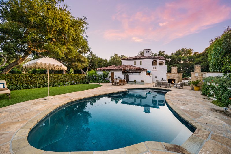 Una residencia espaciosa con una gran piscina en primer plano.